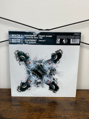 (2010) Negative A / Counterfeit – Disturbing Music For Disturbing Times (Vinyl)